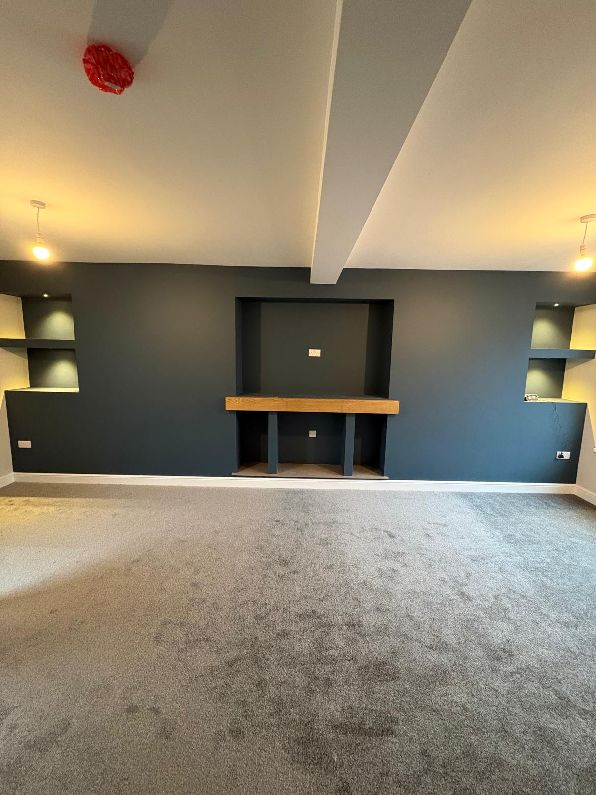 Finished living room with fireplace nook and shelving